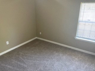 A room with a carpet floor and a window.