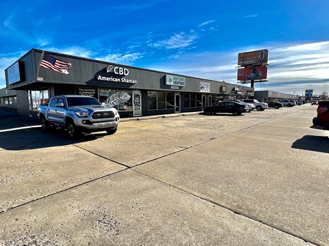 a parking lot with cars parked in front of a cbd store