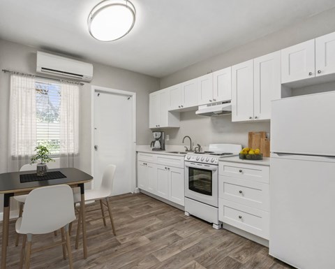 A kitchen with white cabinets and a wooden table.