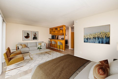 A living room with a brown couch and a painting on the wall.