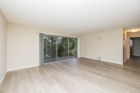 A room with a sliding glass door leading to a backyard.