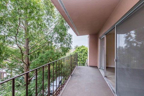 A balcony with a metal railing and sliding glass doors.