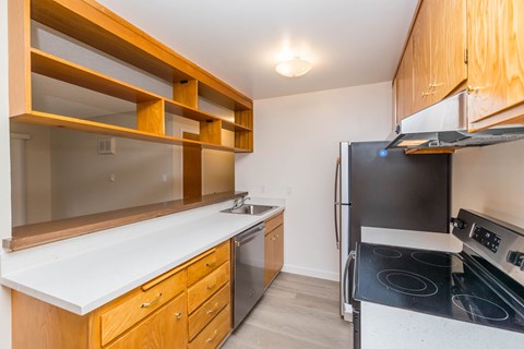 A kitchen with wooden cabinets and a black stove top oven.