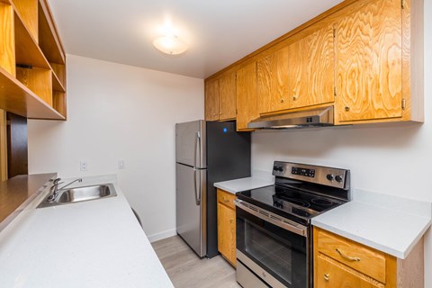 A kitchen with a stove, oven, and sink.