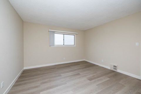 A room with a window and wooden flooring.