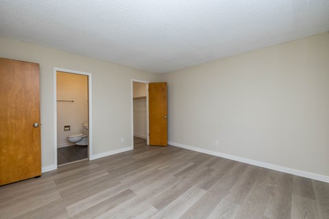 A room with wooden floors and two doors.