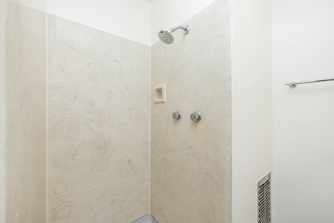 A shower area with a wall mounted shower head.