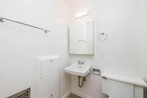 A white bathroom with a sink and mirror.