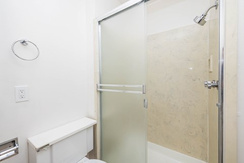 A white bathroom with a glass shower door.