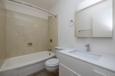 A white bathroom with a toilet, sink, and bathtub.