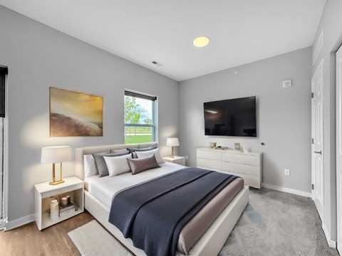 A bedroom with a large bed, a television, and a painting on the wall.