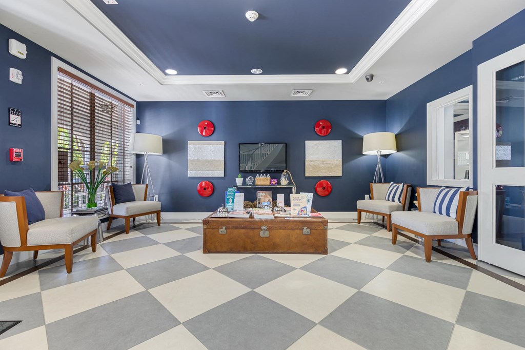 a lobby with chairs and a table and a tv