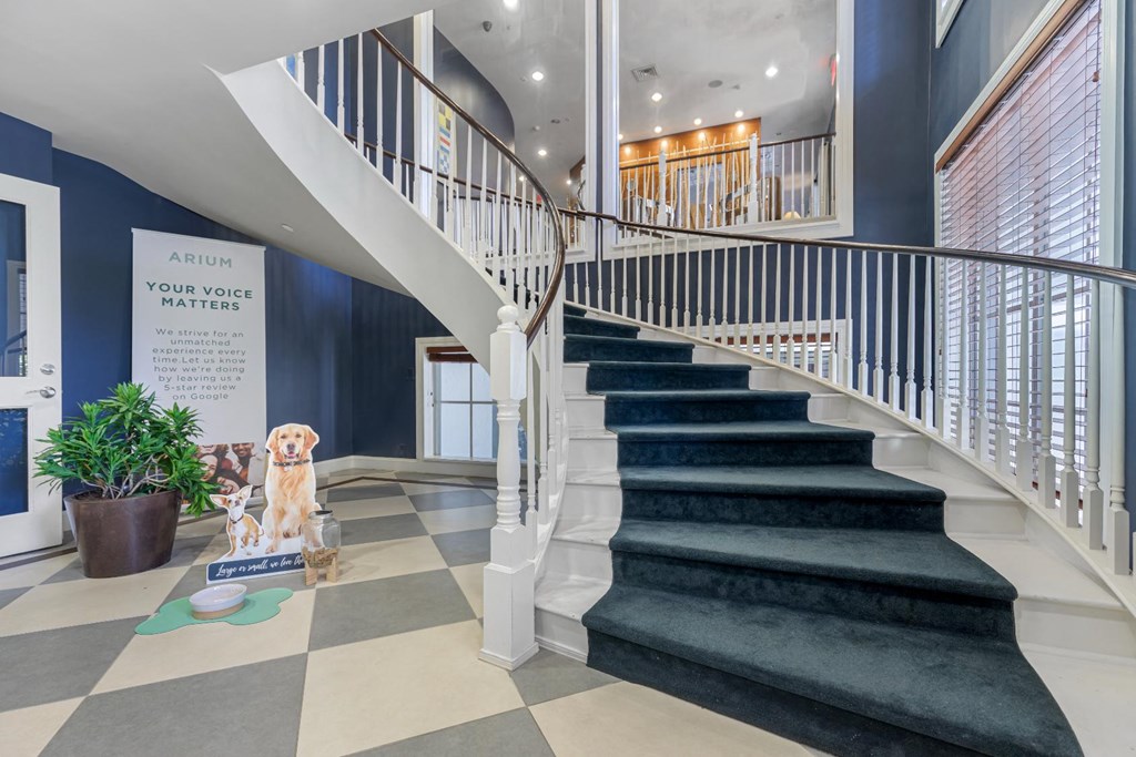 the stairway of a house with a dog statue and a blue staircase