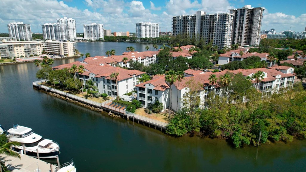 an aerial view of houses next to a body of water