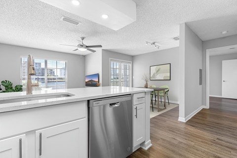 an open kitchen and living room with a large counter top