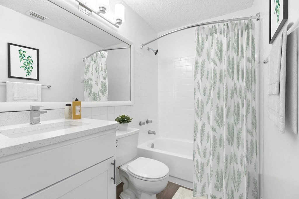 a white bathroom with a shower and a toilet and a sink
