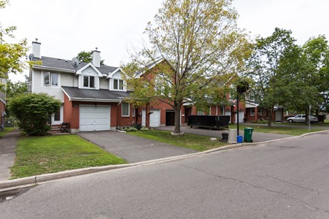 the front of a house with a street in front of it
