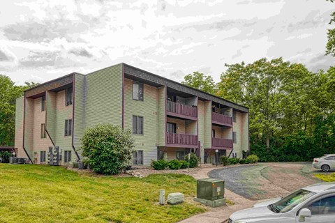 A modern apartment building with a green lawn in front.