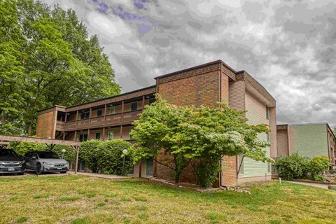 A car is parked in front of a brick building.