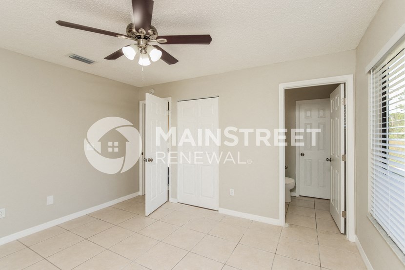 a large bedroom with a closet and a ceiling fan