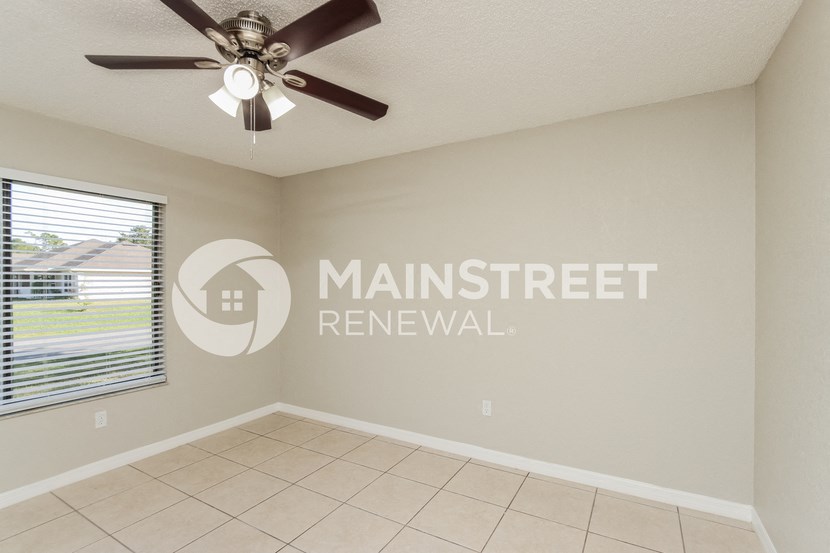 a living room with a ceiling fan and a window