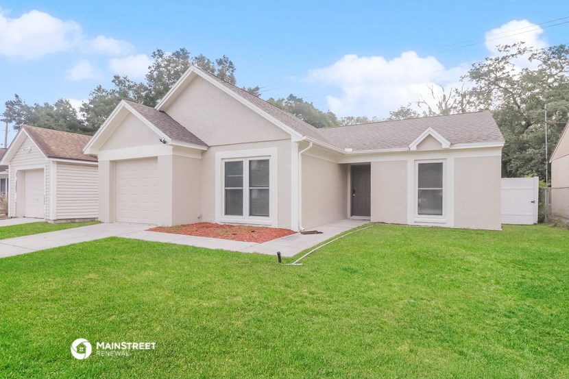 a small white house with a yard and grass