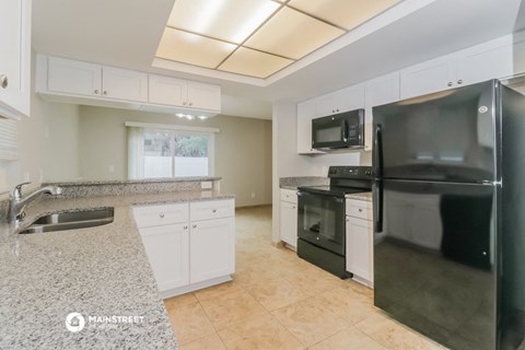 a large kitchen with stainless steel appliances and granite counter tops