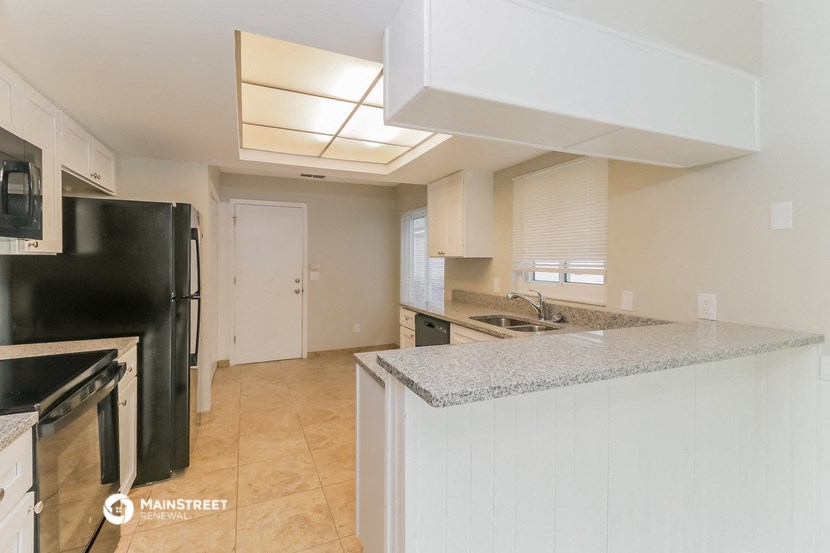 a kitchen with a counter top and a black refrigerator