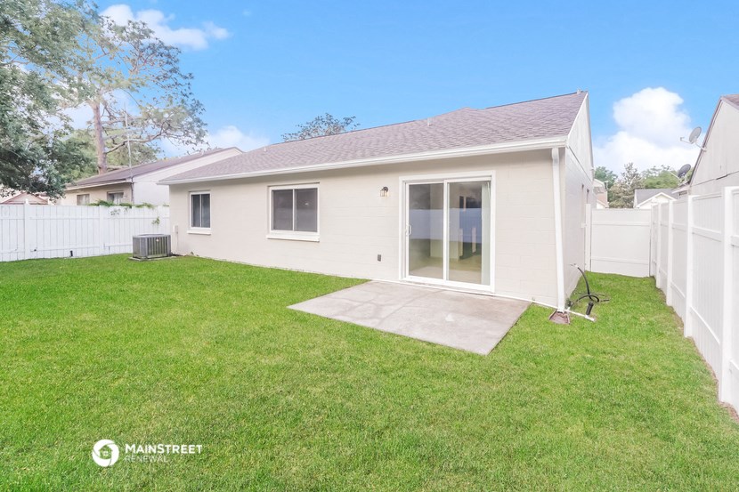 a small white house with a yard and a patio