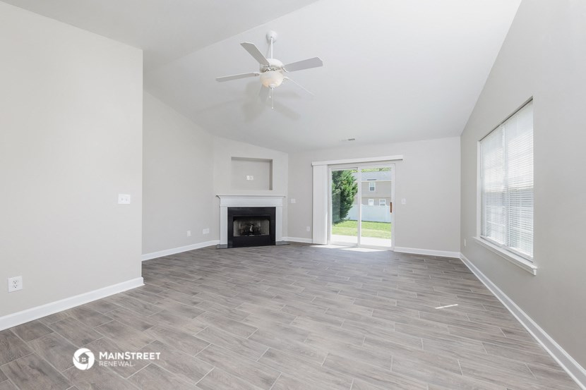 a living room with a fireplace and a ceiling fan
