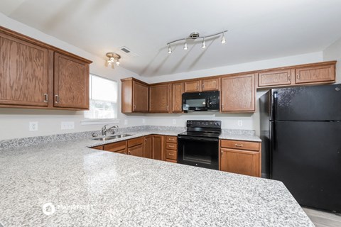 a kitchen with granite counter tops and wooden cabinets