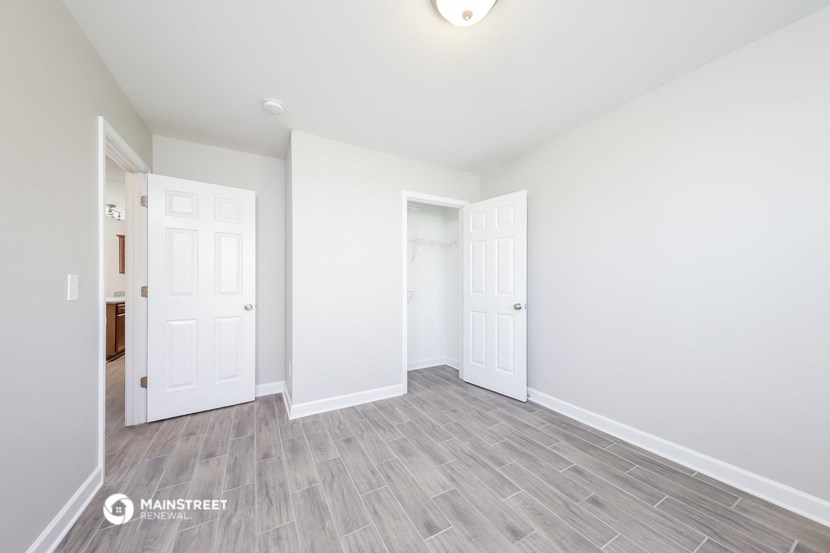 the living room of a new home with white walls and wood flooring