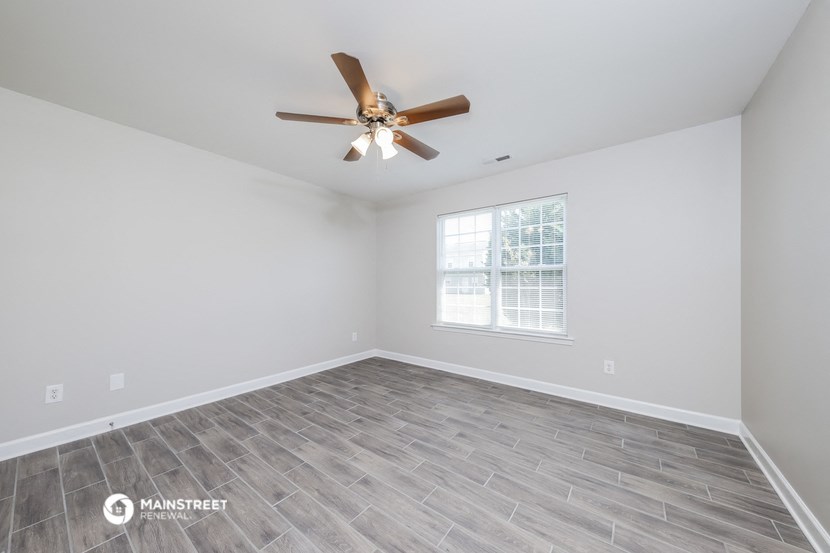 the living room of a new home with a ceiling fan
