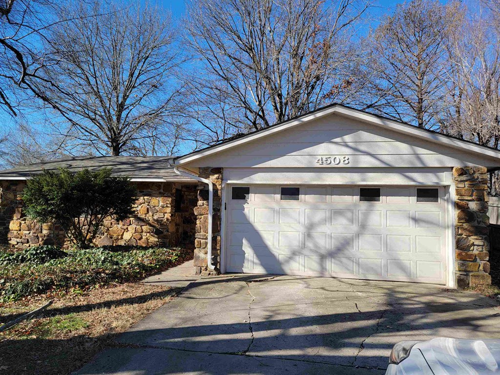 a white garage door in front of a house with a driveway