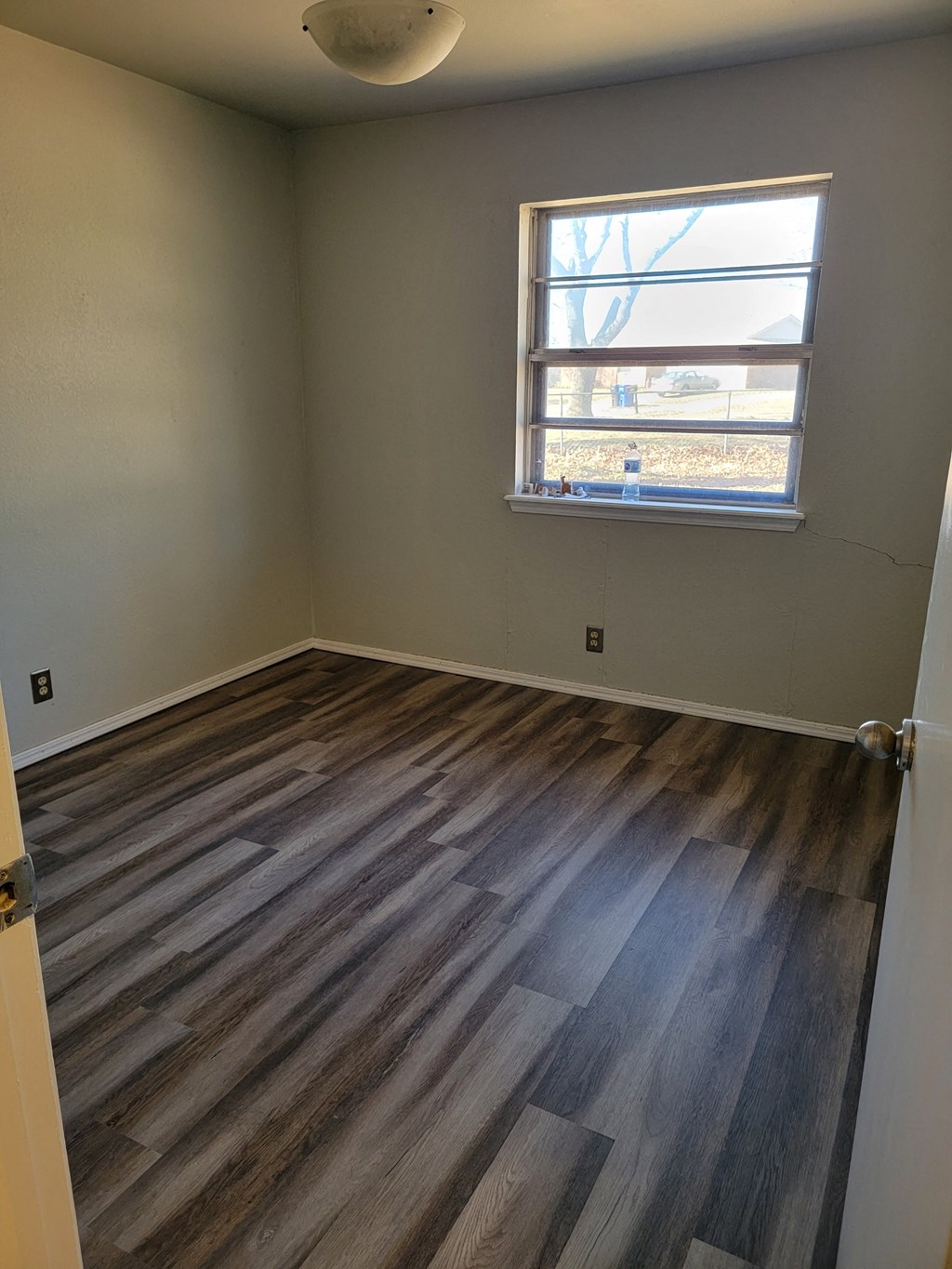 an empty room with wooden floors and a window