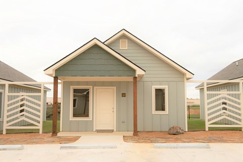 A small house with a grey and green exterior.