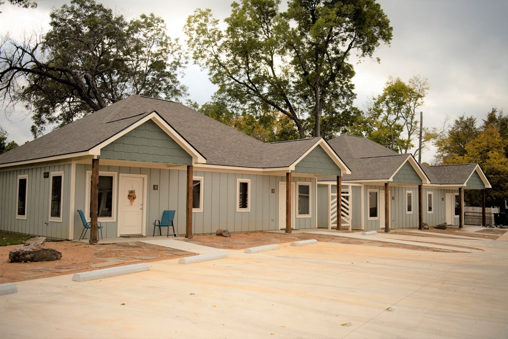 a row of houses with a yard and a porch