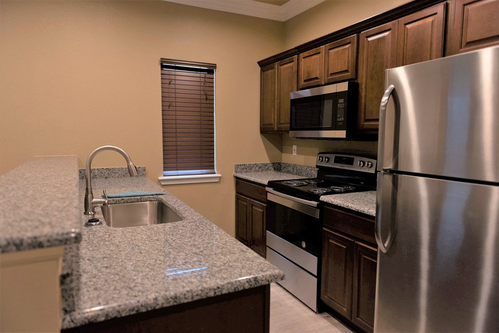 a kitchen with granite counter tops and stainless steel appliances