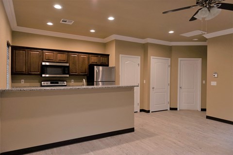 a kitchen with a counter and a refrigerator and a microwave