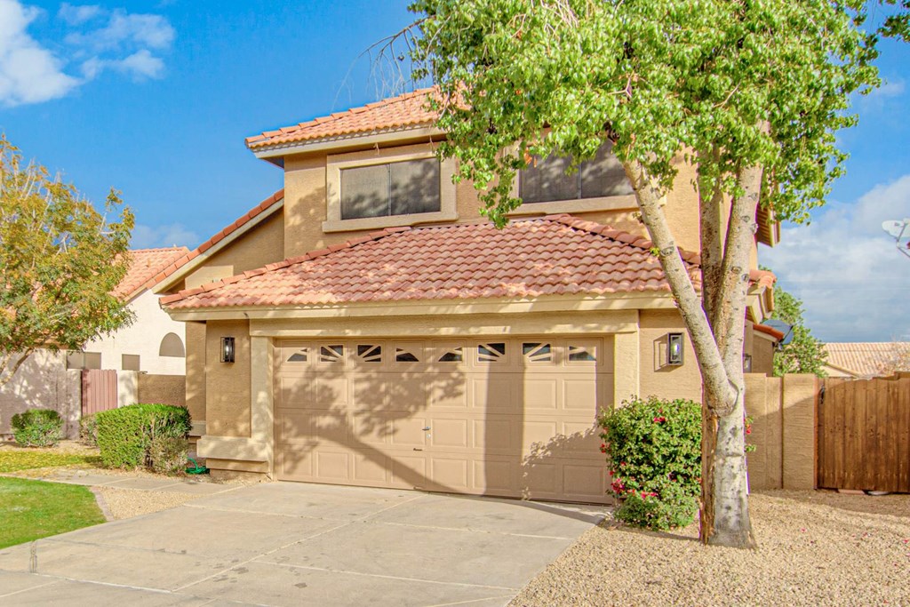 a garage door with a tree in front of a house