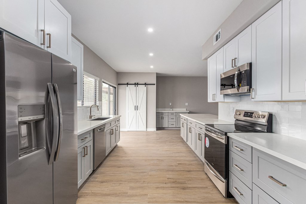a kitchen with white cabinets and stainless steel appliances