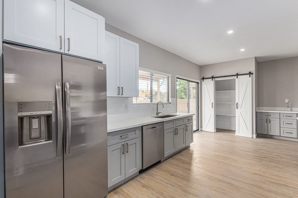 a renovated kitchen with stainless steel appliances and white cabinets