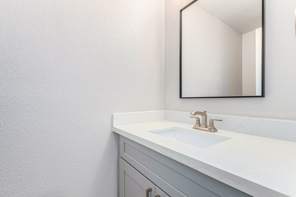 an empty bathroom with a sink and a mirror