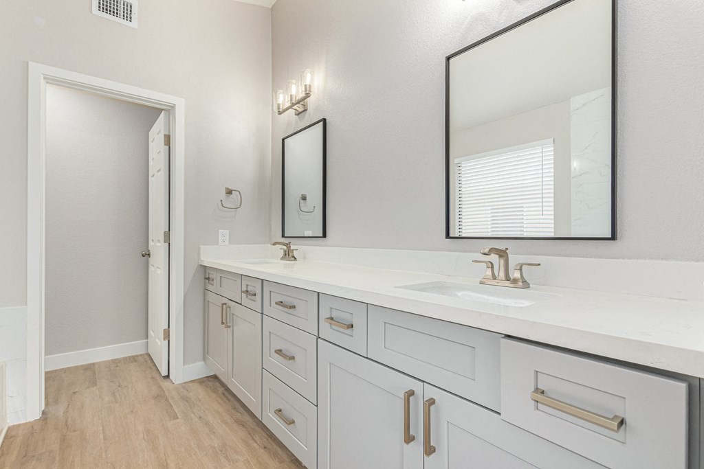 a bathroom with white cabinets and a sink and a mirror