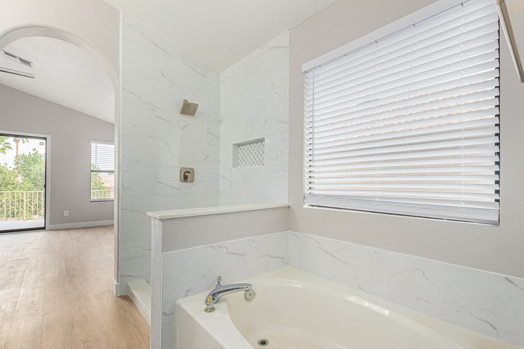the master bathroom has a large tub and a large window