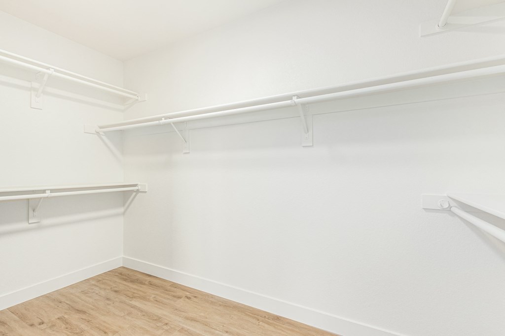 an empty room with white walls and a wood floor