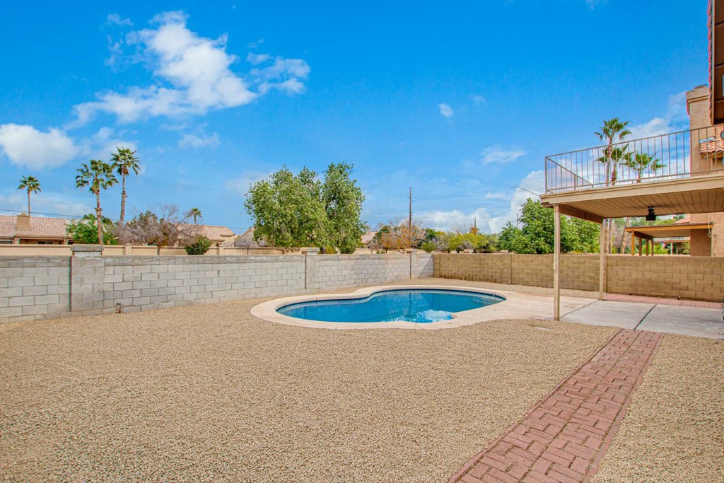 a small pool in the backyard of a house with a deck