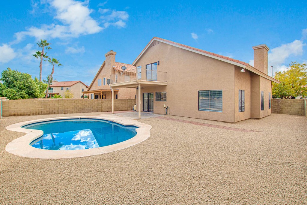 a pool in the backyard of a house with a patio