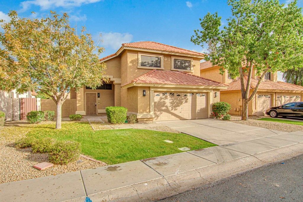 a house with a driveway and a car in front of it