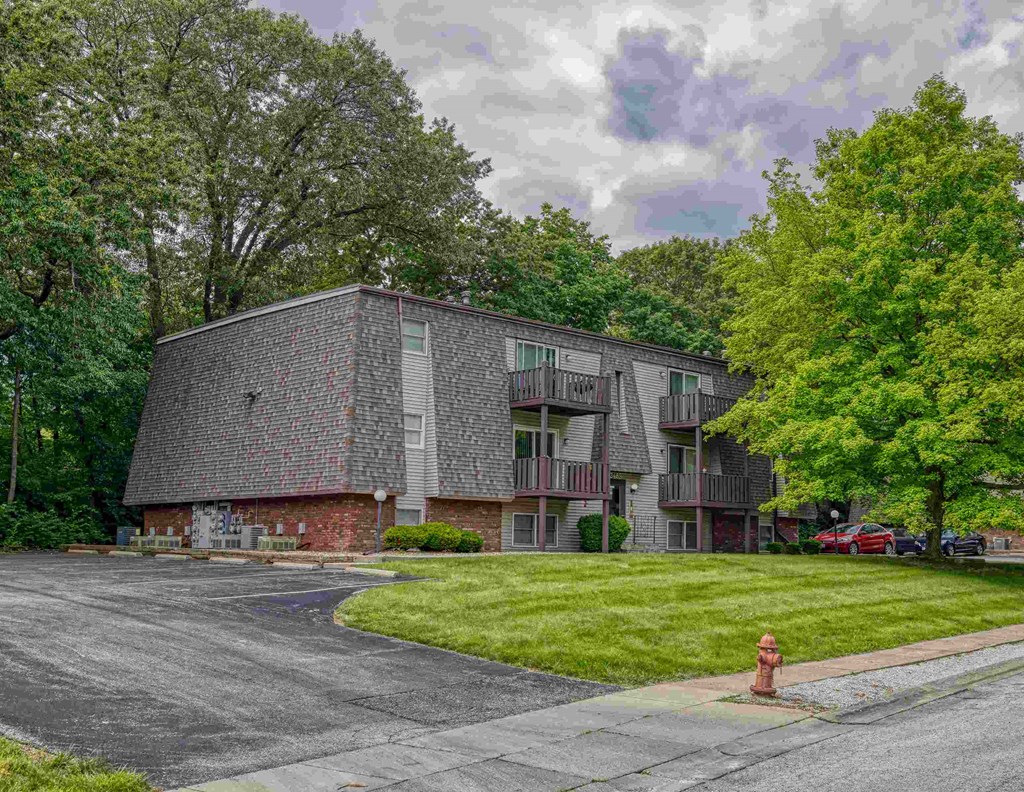 A grey building with a red fire hydrant in front of it.